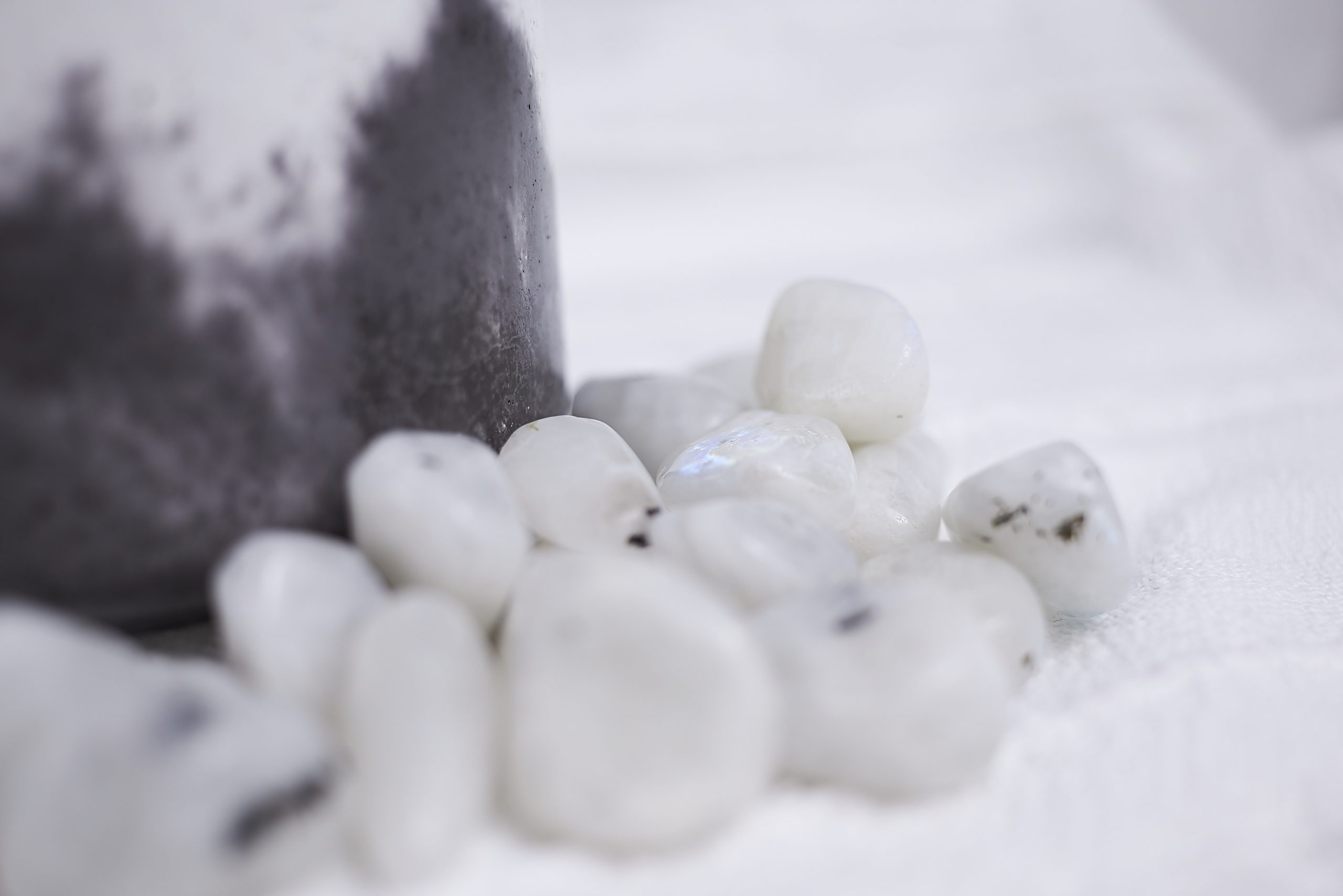 Vela de soja aromática NUR 8 Detalle de la vela de soja madera y cuero NUR en envase de cemento, decorada con piedra luna