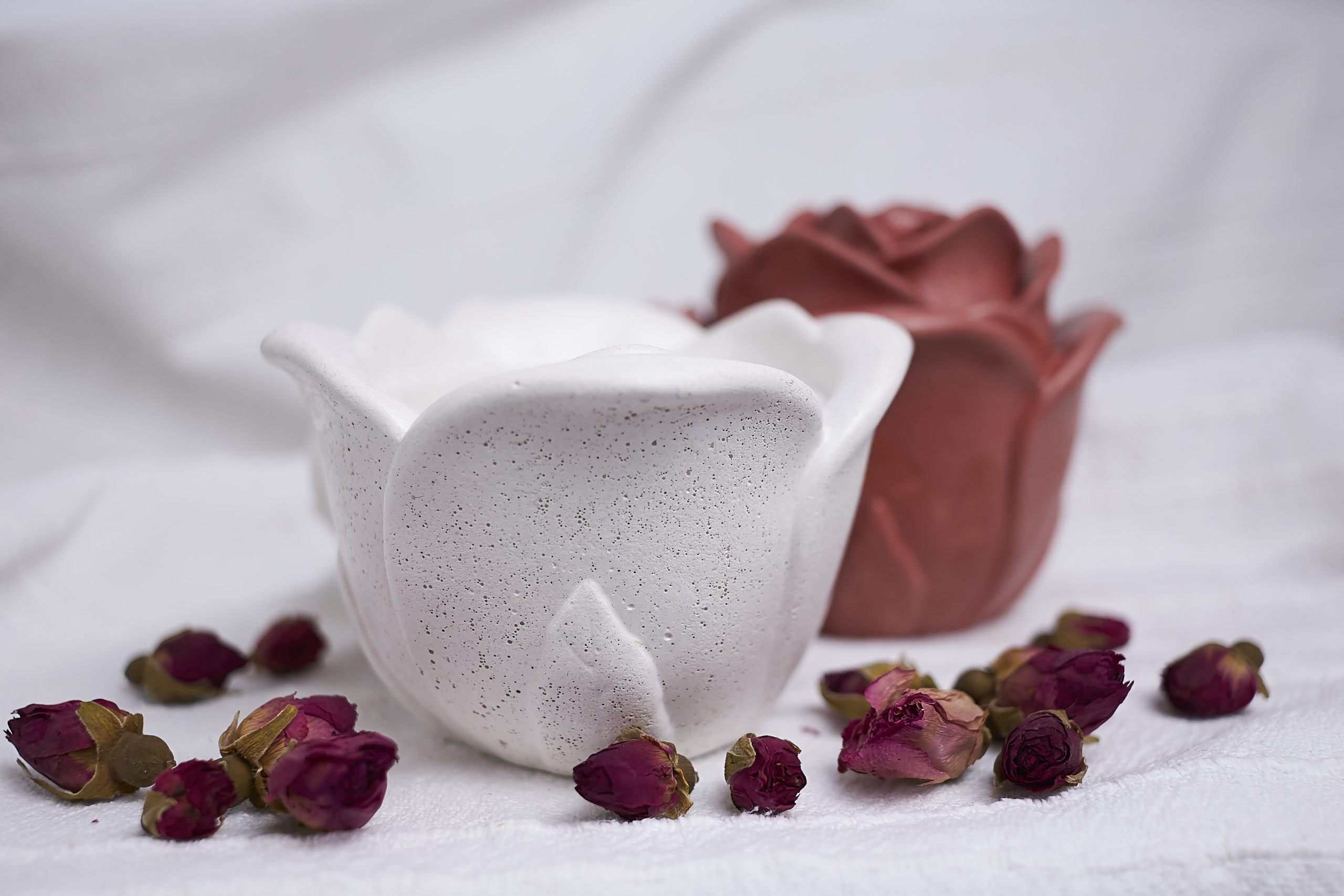 Vela de soja aromática Rosa & Oud 3 Detalle del envase artesanal de cemento con diseño de rosa en color blanco y rojo con aroma floral y amaderado
