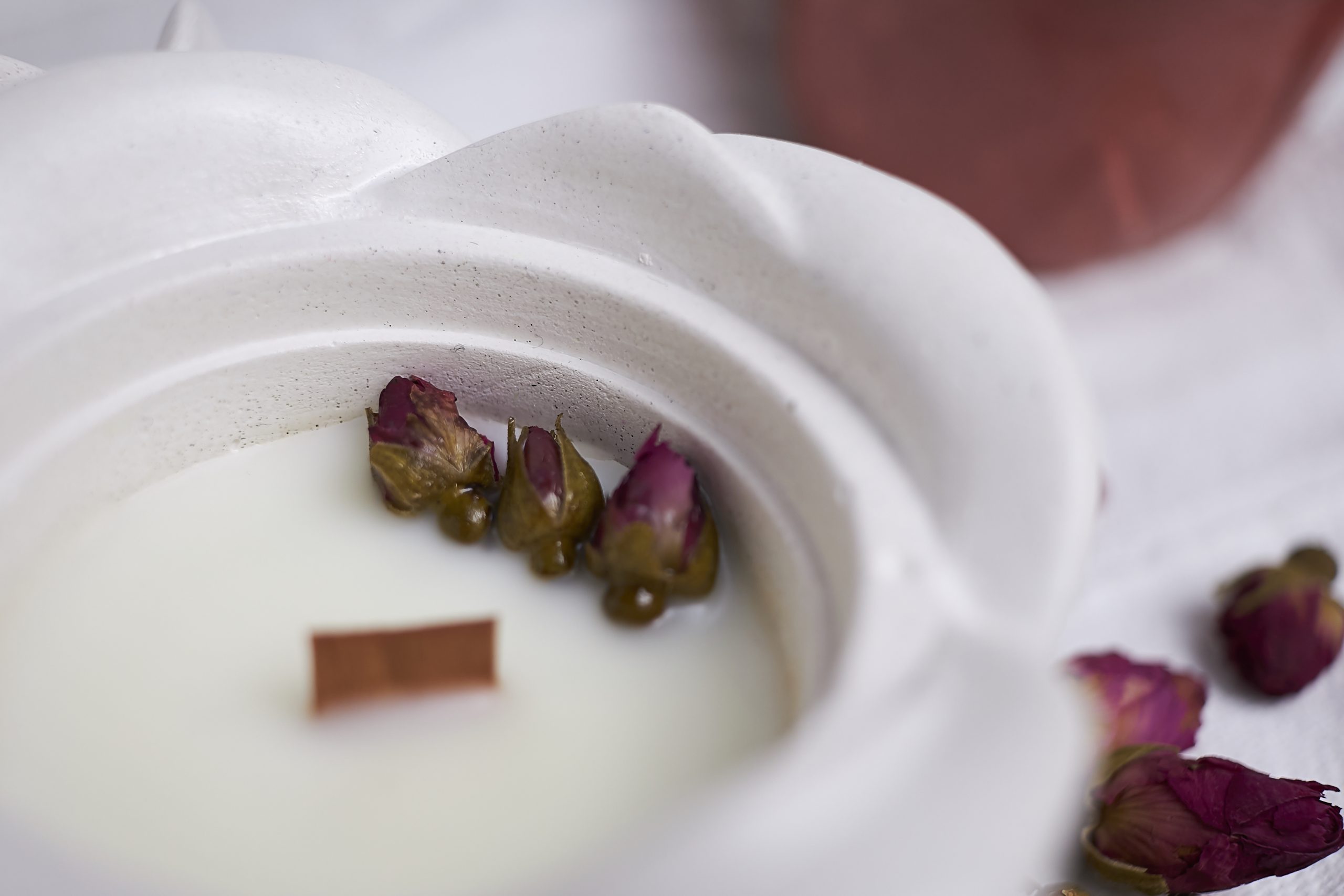 Vela de soja aromática Rosa & Oud 10 Detalle del envase artesanal de cemento con diseño de rosa en color blanco con aroma floral y amaderado