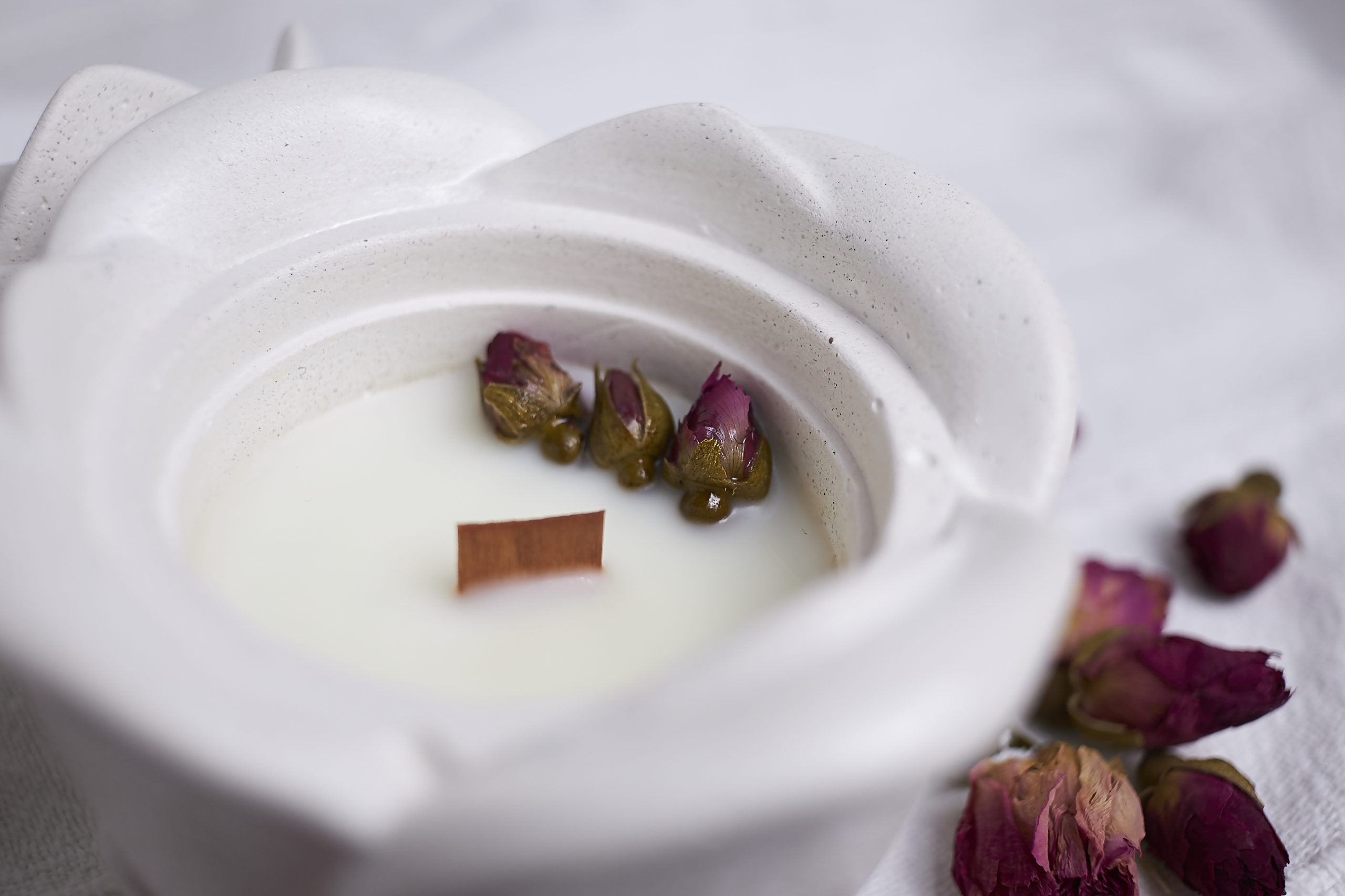 Vela de soja aromática Rosa & Oud 9 Detalle del envase artesanal de cemento con diseño de rosa en color blanco con aroma floral y amaderado