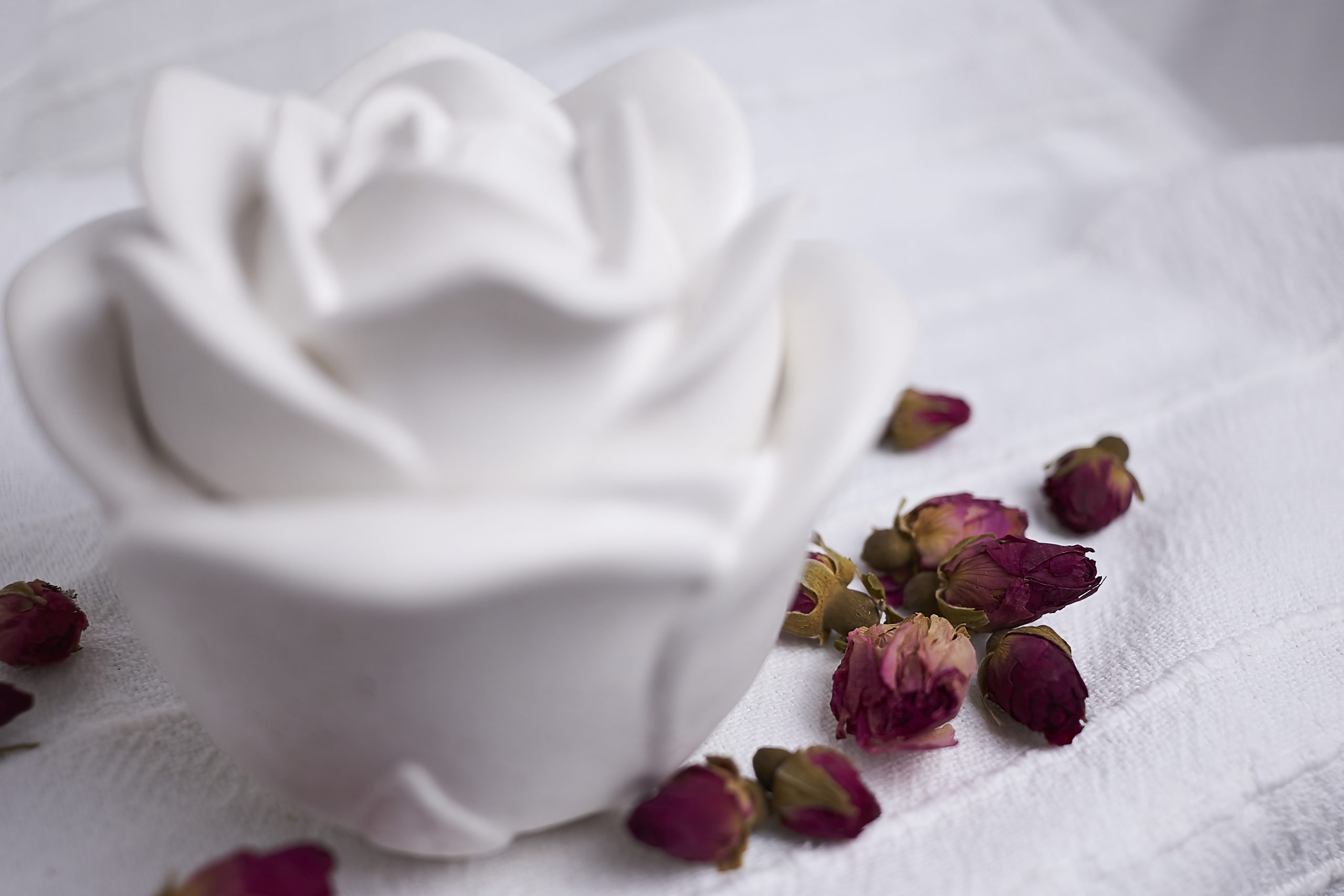 Vela de soja aromática Rosa & Oud 4 Detalle del envase artesanal de cemento con diseño de rosa en color blanco con aroma floral y amaderado