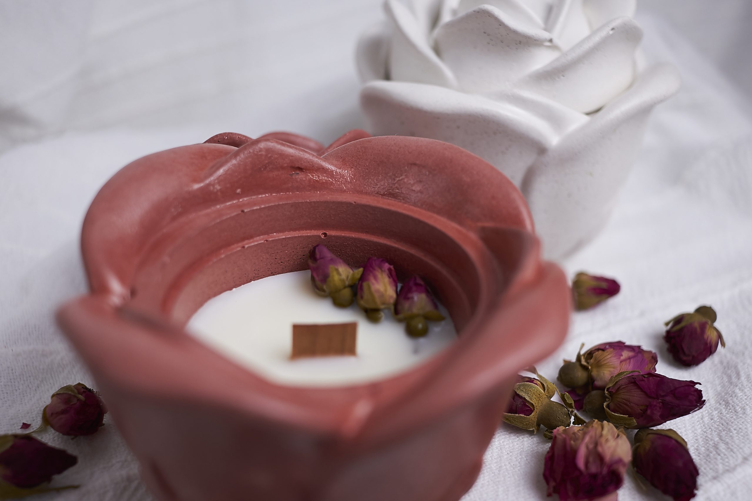 Vela de soja aromática Rosa & Oud 2 Detalle del envase artesanal de cemento con diseño de rosa en color rojo con aroma floral y amaderado