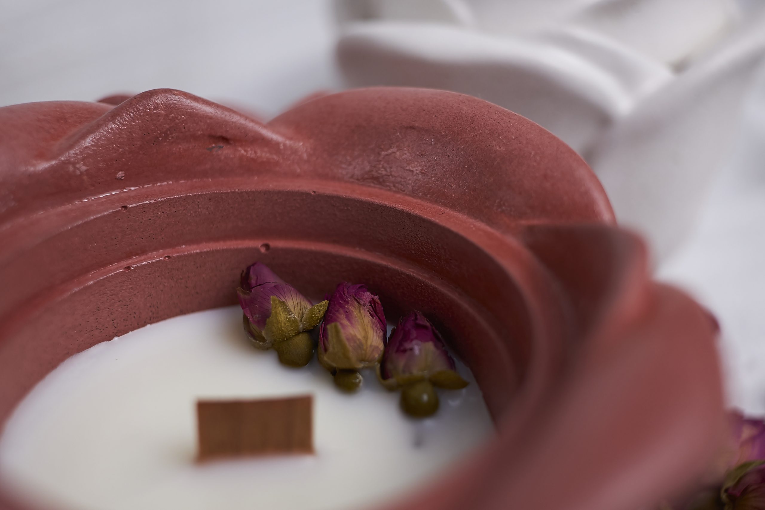 Vela de soja aromática Rosa & Oud 6 Detalle del envase artesanal de cemento con diseño de rosa en color rojo con aroma floral y amaderado