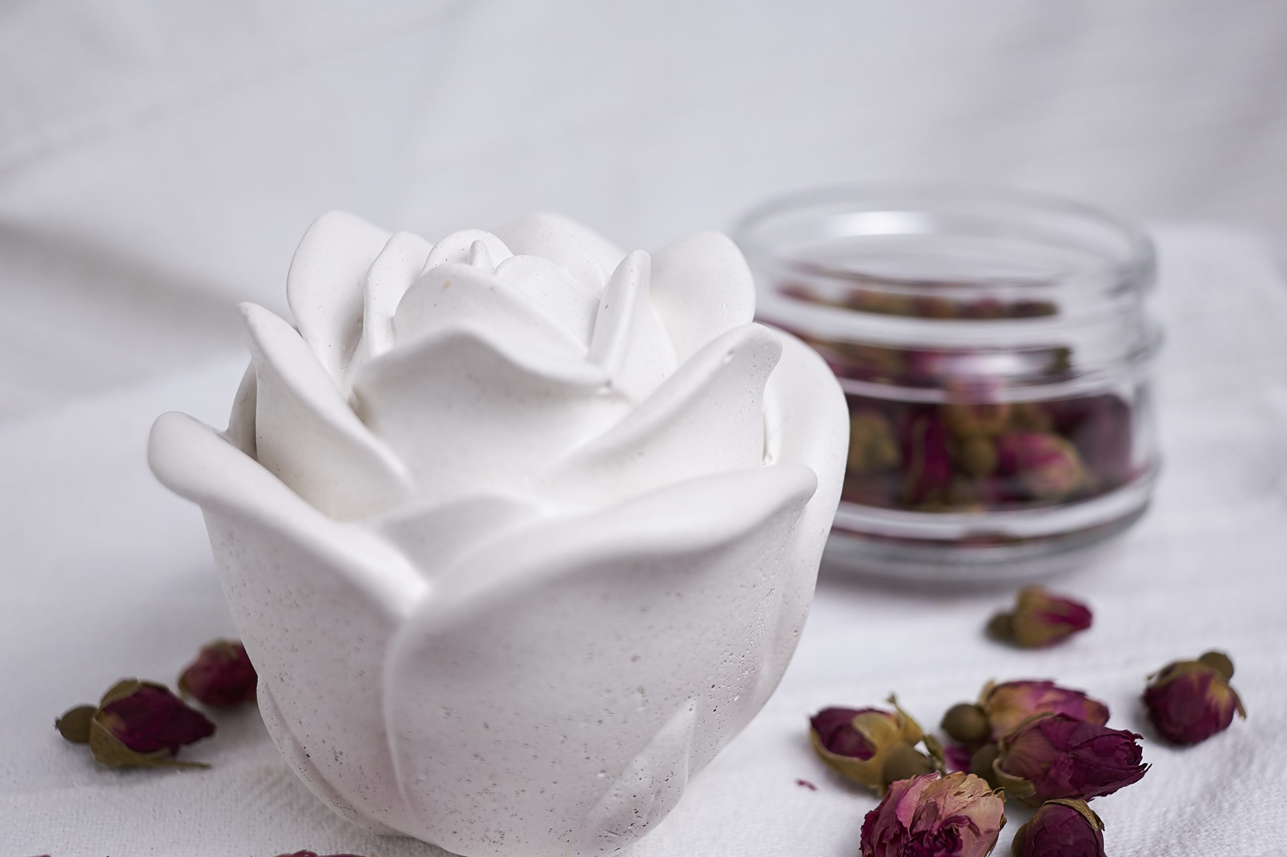 Vela de soja aromática Rosa & Oud 5 Detalle del envase artesanal de cemento con diseño de rosa en color blanco con aroma floral y amaderado