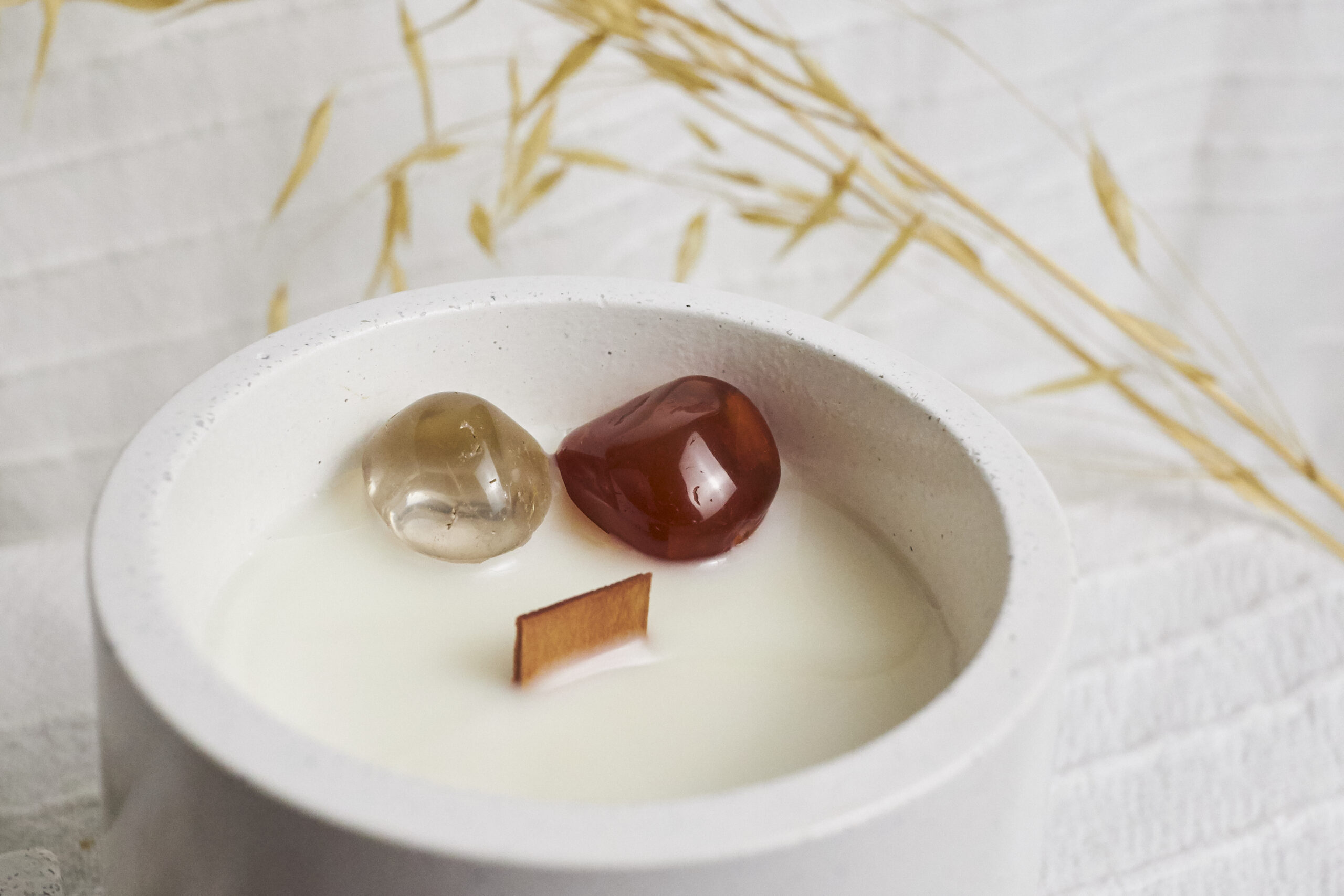 Vela de soja aromática Ámbar & Sándalo 5 Detalle de la vela Ámbar & Sándalo con decoración de cornalina y cuarzo ahumado de NUR atelier de velas